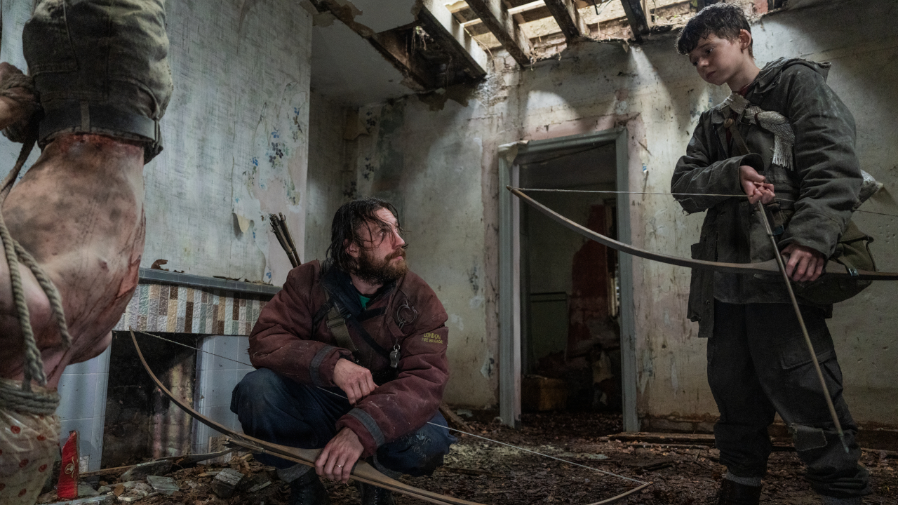 28 Years Later movie still showing survivors with bows in post-apocalyptic setting.