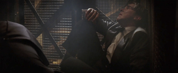 Alfred Pennyworth tends to an injured and distraught Bruce Wayne in a moment of vulnerability from Batman Begins.